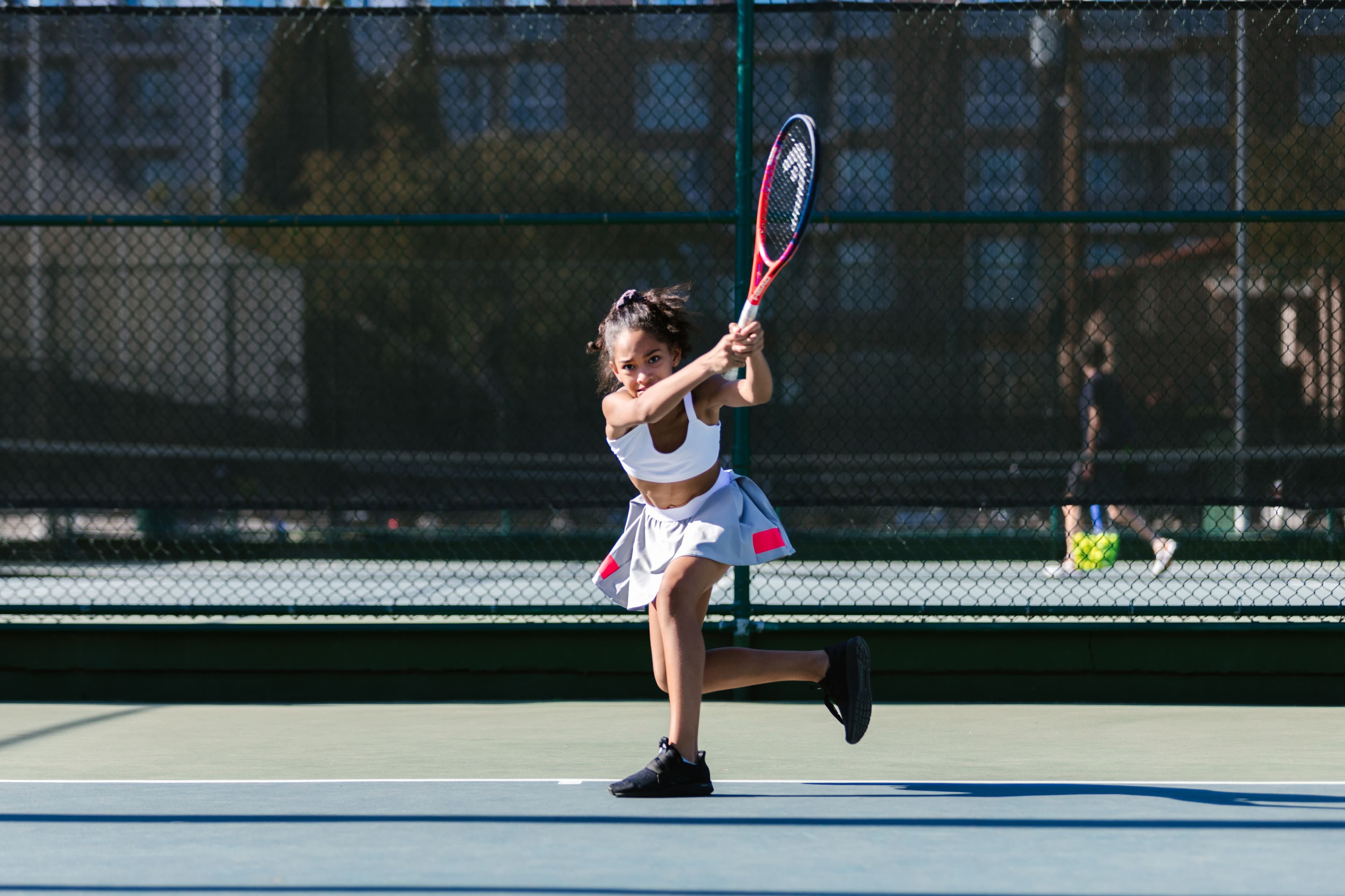 Young girl playing tennis on an outdoor court